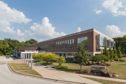 exterior of moline public library building with trees and bright blue sky